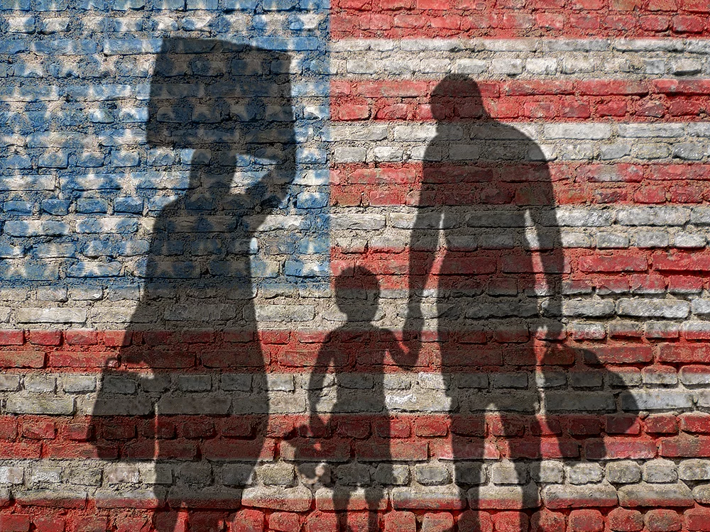 family in Silhouette in front of flag