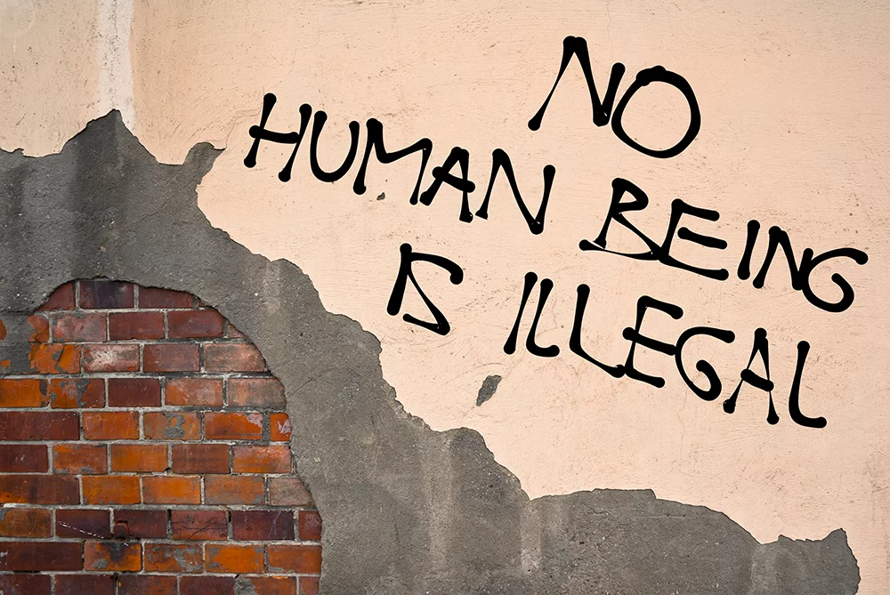 no human being is illegal written on wall