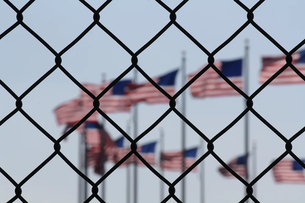 American Flags behind a chain link fence
